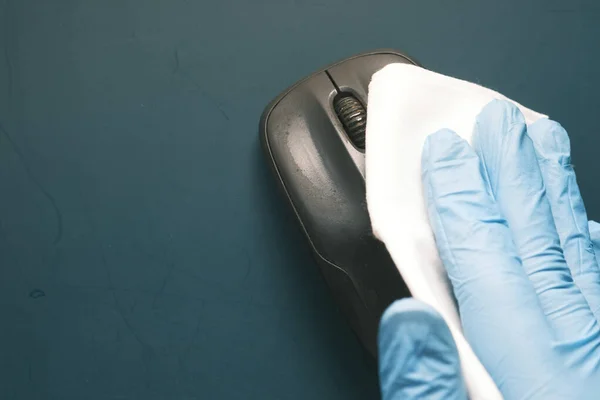 Mavi lastik eldivenler ve bilgisayar faresini dezenfekte eden beyaz doku. — Stok fotoğraf