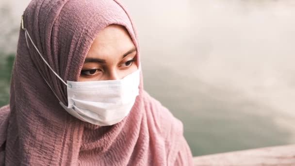 Mulher muçulmana pensativo com máscara de gripe olhando para longe — Vídeo de Stock