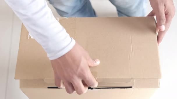 Vue du dessus de la boîte en carton vide ouverte sur la table. — Video