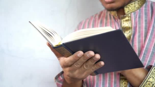 Homem muçulmano mão segurando livro sagrado Alcorão com espaço de cópia — Vídeo de Stock