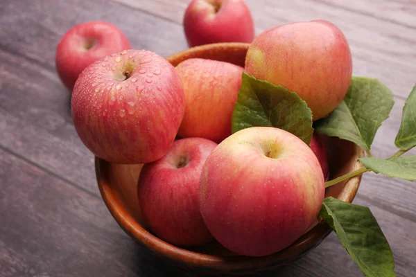 Närbild av färskt äpple i en skål på träbord — Stockfoto