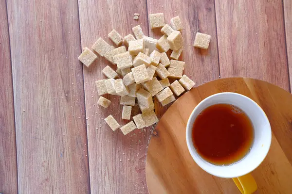 Чашка чая и сахара кубик на столе — стоковое фото