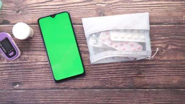 Vista dall'alto di smart phone, contenitore pillola e blister sul tavolo — Video Stock