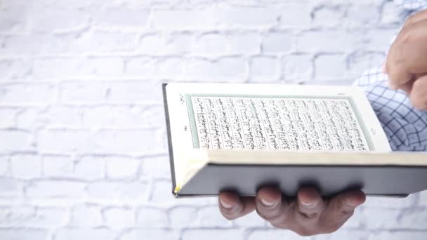 Man som håller i den heliga boken Koranen närbild — Stockvideo