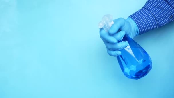 Hand in blue rubber gloves holding spray bottle with copy space — Stock Video