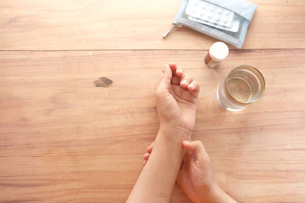  Молодые женщины страдают от боли в запястьях и таблеток на столе 