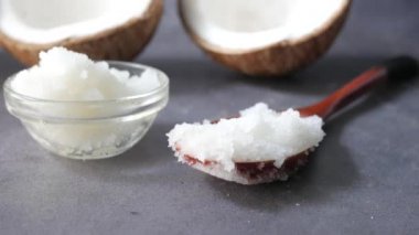 Hindistan cevizi yağlı kaşık ve siyah arka planda fındık 