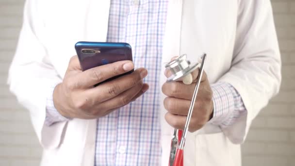 의사들은 스마트폰 과 청진기를 들고 보호 장갑을 끼고 있다 — 비디오