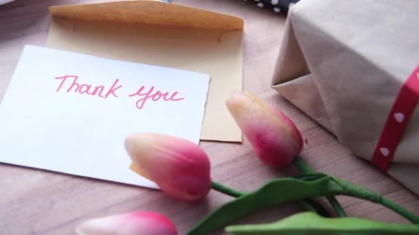 Dankeschön-Nachricht und Umschlag auf Holztisch — Stockvideo