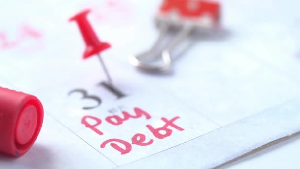 Primer plano de la palabra deuda de pago en el calendario — Vídeos de Stock
