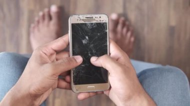 Kırık akıllı telefonu tutan adamın en üst görüntüsü. 