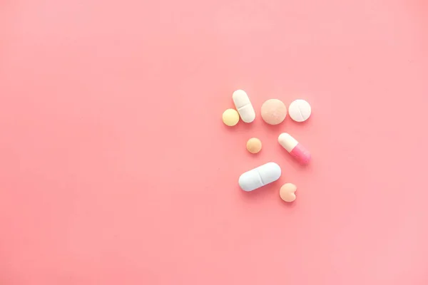 Close up of many colorful pills and capsules on pink background — Stock Photo, Image