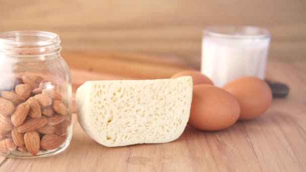 Nahaufnahme von Käse, Milch, braunem Brot und Mandelnüssen auf dem Tisch. — Stockvideo