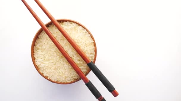 Long grain brown rice in a bowl on white background — Stock Video