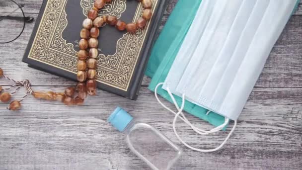 Холлі книга Курана, молитовний розарій, дезінфікуючий засіб для рук та маска на підлозі — стокове відео