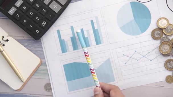 Finansgraf, räknare och anteckningsblock på tabell — Stockvideo