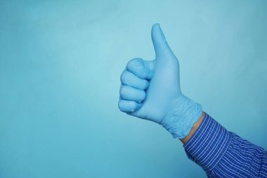 Adam eli mavi arka planda baş parmak gösteriyor 