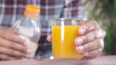  Bir bardak portakal suyu tutan bir adam.