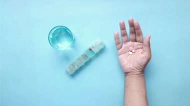 İlaç kutusundan dökülen ilaçlı adam eli. 