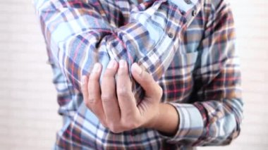 Dirsek ağrısı olan bir adam, ağrı kesici konsept.