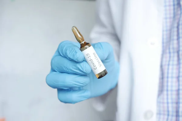 Χέρι σε γάντια λατέξ που κρατούν το εμβόλιο γυάλινη φύσιγγα, με χώρο αντίγραφο — Φωτογραφία Αρχείου