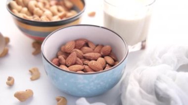 Beyaz arka planda fıstık, badem fıstığı ve süt. 