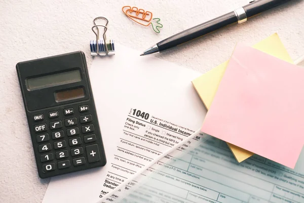 Formularz deklaracji podatkowej, kalkulator, papier i długopis na stole. — Zdjęcie stockowe