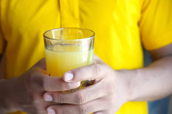 Sosteniendo un vaso de jugo de naranja de cerca — Foto de Stock