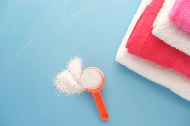 Mavi arka planda plastik kaşıkla yıkama tozu 