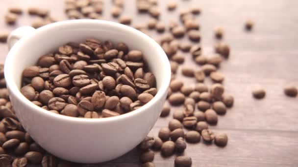 コピースペースと黒の背景にカップで新鮮なコーヒー豆のクローズアップ. — ストック動画