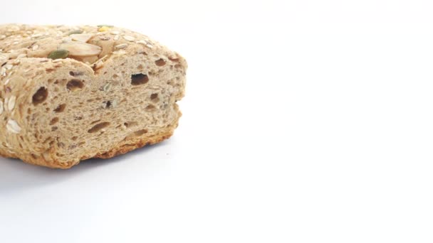 Vollkornbrot in Scheiben auf weißem Hintergrund — Stockvideo