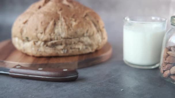 Ost, mjölk, brunt bröd och mandelnötter på bordet. — Stockvideo