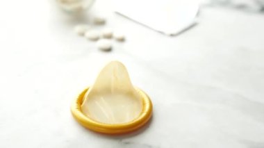 Prezervatifi kapat ve tahta arka planda haplar var. 