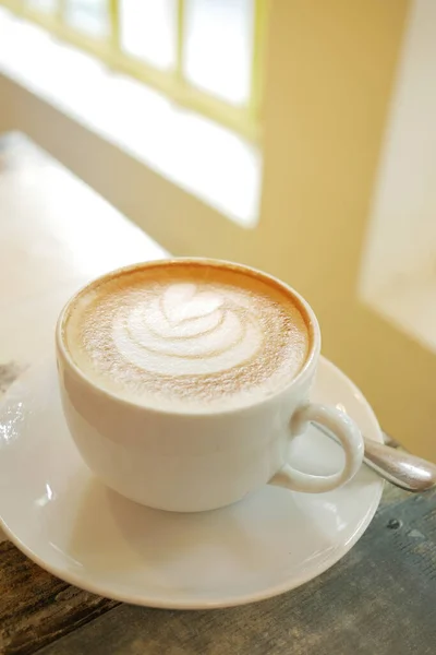 Uma xícara de café tarde com design de forma de flor no topo no café — Fotografia de Stock