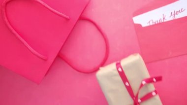 Bir alışveriş çantasında hediye kutusu ve masadaki teşekkür mektubu. 