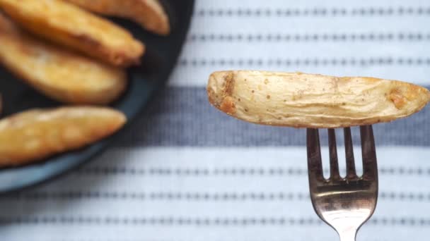 Sluiten van aardappelpartjes met vork — Stockvideo