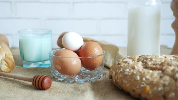 Oeufs dans un bol, pain complet et lait sur la table — Video