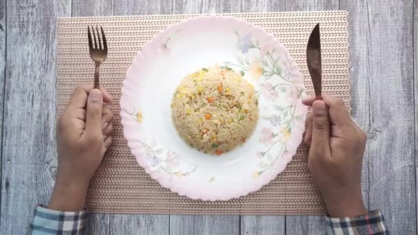 Ung man med gaffel väntar på en tallrik full med ris — Stockvideo