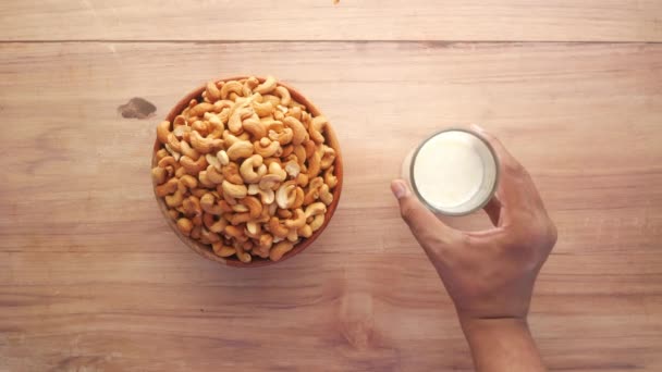 Nuez de anacardo y vaso de leche en la mesa, puesta plana — Vídeo de stock