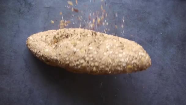 Vollkornbrot fällt auf schwarzem Hintergrund — Stockvideo