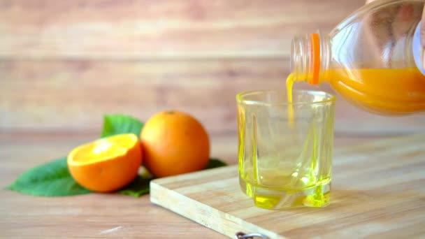 Arancia fresca e bicchiere di succo sul tavolo — Video Stock