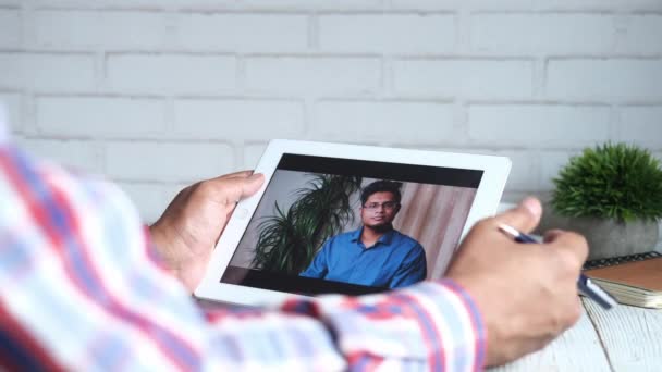 Бизнесмен с цифровым планшетом обсуждает идеи на видеоконференции — стоковое видео