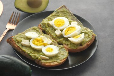 Avokado, kahverengi ekmek, masada haşlanmış yumurta.