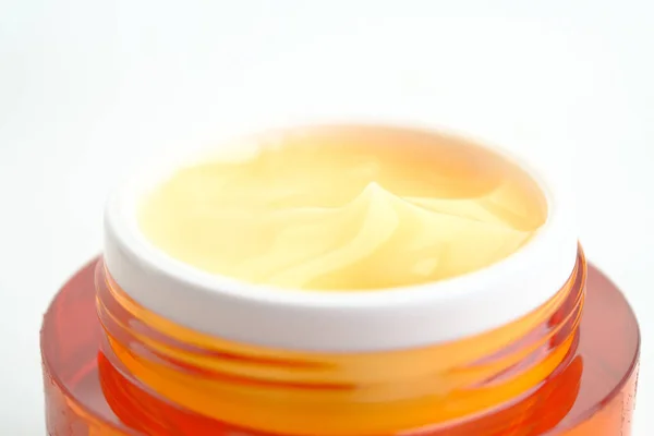 Primer plano de la crema facial en un recipiente naranja aislado en blanco — Foto de Stock