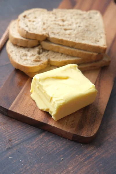 切碎板上的黄油片和全餐面包 — 图库照片