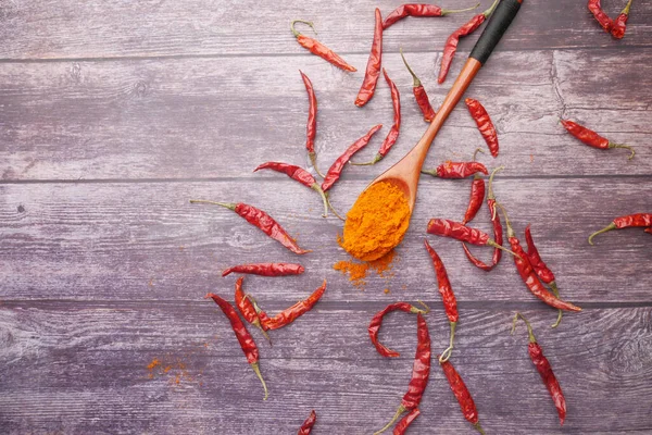 Chili powder and dried peppers on table background.