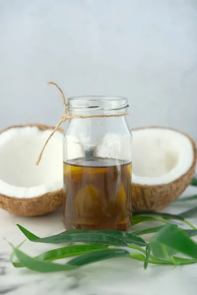 Parte de coco fresco e garrafa de óleo em uma mesa — Fotografia de Stock
