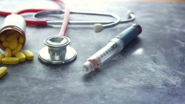 Insulinepennen, medische pillen en stethoscoop op zwart — Stockvideo