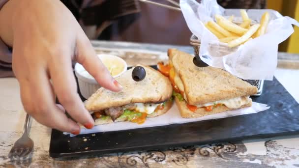 Ломтик сэндвича с говядиной и чипсы на тарелке на столе — стоковое видео