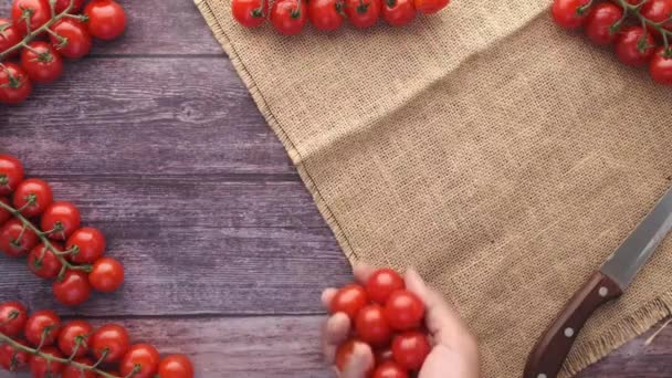 Hand zetten rode kleur cherry tomaat op tafel — Stockvideo